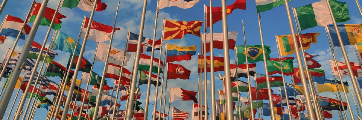 Flags from all over the world against a backdrop of a blue sky
